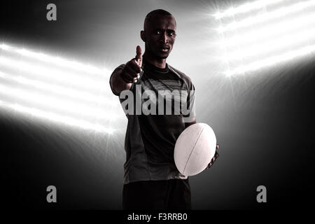 Immagine composita del ritratto di fiduciosa giocatore di rugby che mostra i pollici mentre in piedi Foto Stock