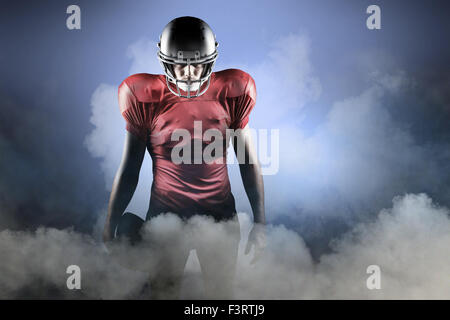 Immagine composita del giocatore di football americano in piedi con sfera Foto Stock