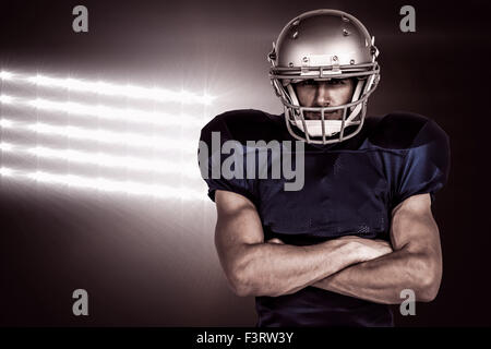 Immagine composita del ritratto fiducioso di giocatore di football americano con le braccia incrociate Foto Stock