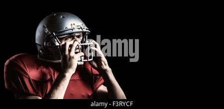 Immagine composita di aggressivo giocatore di football americano casco di contenimento Foto Stock