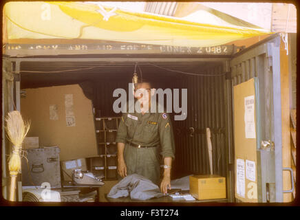 Un soldato americano dell'esercito degli Stati Uniti sta all'interno di un contenitore di conex al Cam Rahn Bay, una posizione del 1° Comando Logistico, durante la Guerra del Vietnam. Foto Stock