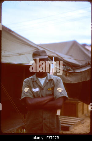 Un Americano nero soldato dell'esercito degli Stati Uniti sta accanto a una tenda al Cam Rahn Bay, una posizione del 1° Comando Logistico, durante la Guerra del Vietnam. Foto Stock