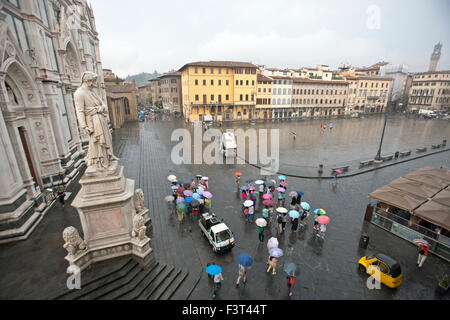 Basilica di Santa Croce con la statua di Dante a Firenze, Italia pioggia e turistico in piazza Foto Stock