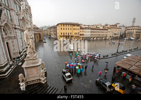 Basilica di Santa Croce con la statua di Dante a Firenze, Italia pioggia e turistico in piazza Foto Stock