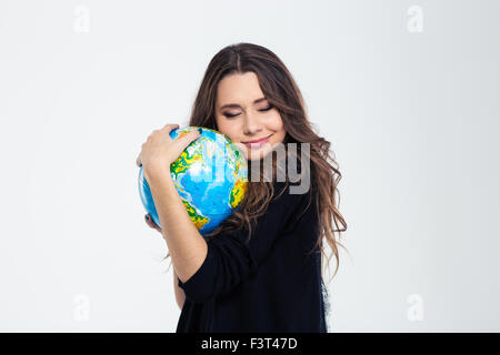 Ritratto di un felice carino donna abbracciando globe isolato su uno sfondo bianco Foto Stock