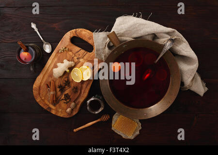 Miele di limone zenzero vin brulé o punzone in ottone recipiente scuro su un tavolo di legno. Vista superiore Foto Stock