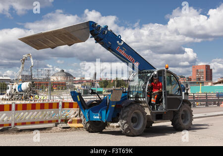 Caricatore frontale la macchina sul suo modo di spostare masse di terra in corrispondenza del sito di sviluppo del nuovo Kalasatama Helsinki quartiere residenziale. Foto Stock