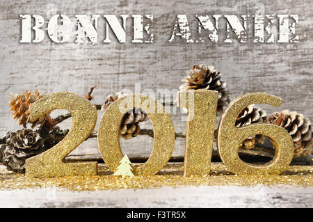 Golden figure con testo 2016 Felice Anno Nuovo (bonne annee in francese) su sfondo di legno Foto Stock