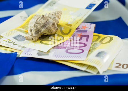 Euro fatture con la bandiera greca e il guscio superiore, con bassa profondità di campo. Turismo astratto di reddito Foto Stock