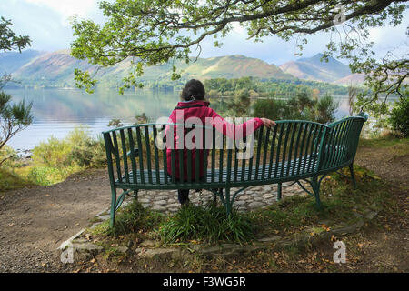 La donna gode di vista pacifica di Derwent Water vicino a Keswick nel Lake District inglese Foto Stock