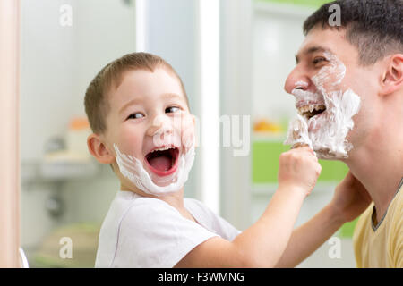 Giocoso padre e figlio di capretto della rasatura e divertirsi nella stanza da bagno Foto Stock