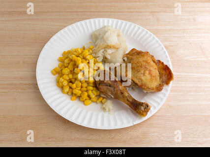 Pollo arrosto coscia e la coscia, purè di patate e grano su un foglio di carta bianca piastra in cima a una tavola di legno alto. Foto Stock