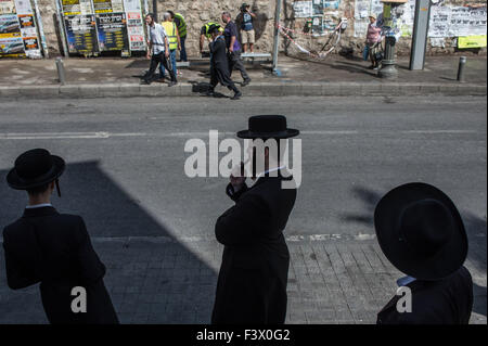 (151013) -- Gerusalemme, 13 ottobre, 2015 (Xinhua) -- Ultra-Orthodox uomini ebraico di guardare il sito di una stazione degli autobus attentato a Gerusalemme, su 13 Ottobre, 2015. Almeno tre israeliani sono stati uccisi e 26 altri feriti in quattro attacchi di palestinesi a Gerusalemme e la città di Ra'anana Martedì mattina la polizia israeliana detta. Un palestinese su un furgone con il logo di Israele nazionale di telecomunicazioni della società, Bezeq, correva su pendolari in corrispondenza di una stazione di autobus in Geula quartiere nel centro di Gerusalemme. Egli si è poi recato al di fuori del suo veicolo, che trafigge i passanti con un coltello. Servizi di salvataggio ha detto che ha ucciso e ferito a le Foto Stock