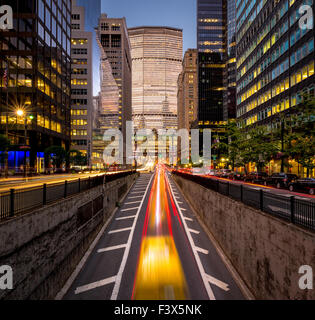 Auto sentieri di luce in Park Avenue South, Midtown Manhattan. Luce della Sera su New York City grattacieli e Grand Central Terminal Foto Stock