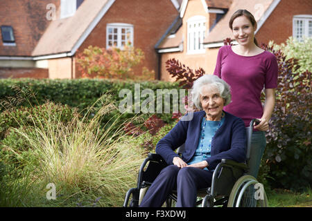Figlia di spinta madre Senior in carrozzella Foto Stock