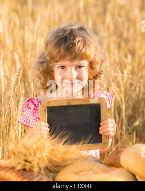 Bambino felice con il pane nel campo Foto Stock