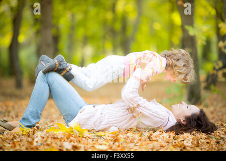 La famiglia felice in autunno park Foto Stock