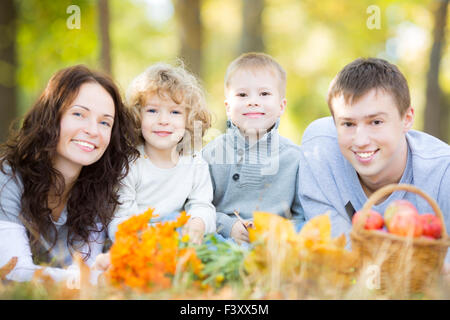 La famiglia felice avente picnic nel parco di autunno Foto Stock