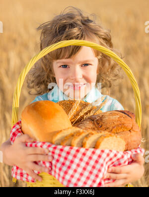 Bambino tenendo il pane nel cestino Foto Stock