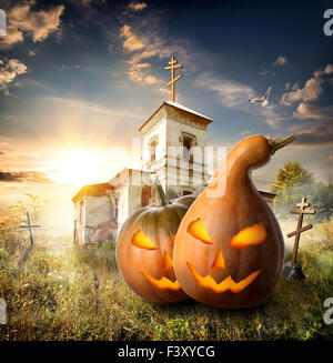 Zucche di Halloween su un cimitero vicino alla vecchia chiesa Foto Stock
