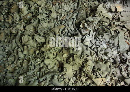 Piano di un'aula all'abbandonato la scuola media n. 3 coperte di bambino dimensionato di maschere antigas. Pripjat, Chernobyl Exclusione Zona. Foto Stock