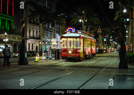 Il Canal Streetcar di notte tra le luci al neon e le decorazioni natalizie rendono un ambiente festoso nel Big Easy, New Orleans, LA, Stati Uniti Foto Stock