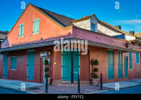 La colorata Vecchia edificio ad angolo con persiane verdi nel Quartiere Francese, New Orleans, LA Foto Stock