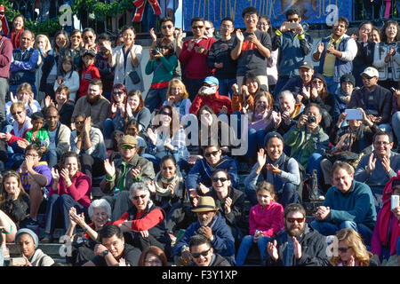 Folla di persone etnicamente diverse di tutte le età, negli Stati Uniti, alcuni seduti, alcuni in piedi mentre ride e applaudendo mentre si guarda l'arte dello spettacolo Foto Stock