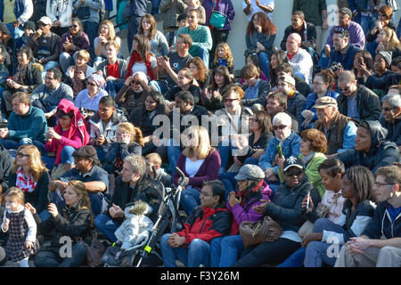 Moltitudine di diverse persone negli Stati Uniti seduti sulle gradinate reagire e la visione di un evento Foto Stock