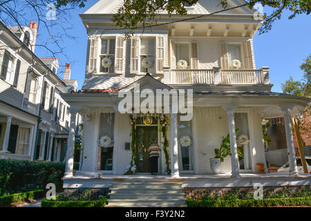 Un visitatore alla porta di un classico Quartiere Giardino mansion, decorata per le vacanze in New Orleans LA Foto Stock