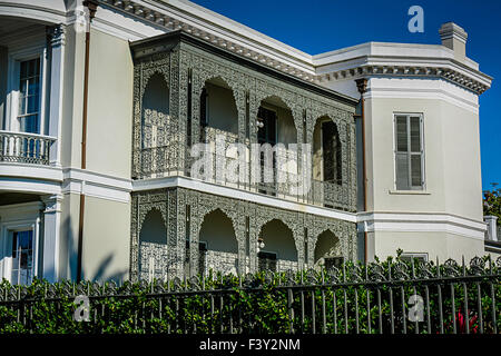 Vista sul marciapiede di una splendida mansion dietro una recinzione in ferro ornato di balconi di ferro nel Garden District di New Orleans, LA Foto Stock