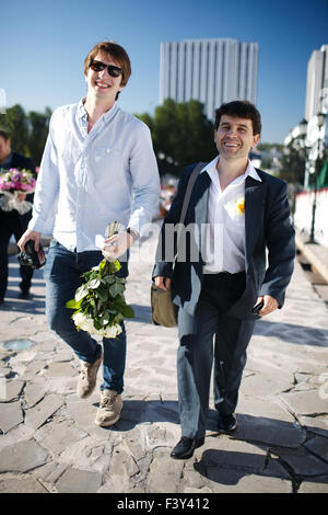 Due uomini sorridenti a piedi giù per una strada Foto Stock