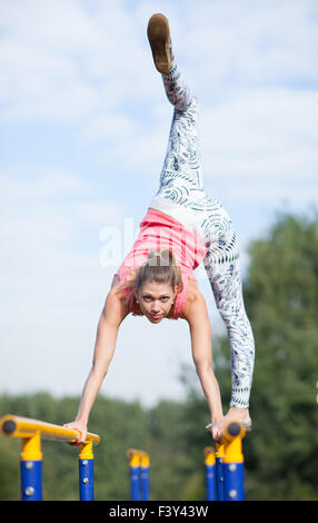 Agile ginnasta giovani in equilibrio su barre trasversali Foto Stock