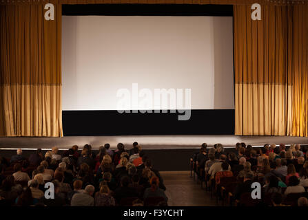 Pubblico di fronte a white cinema schermo Foto Stock