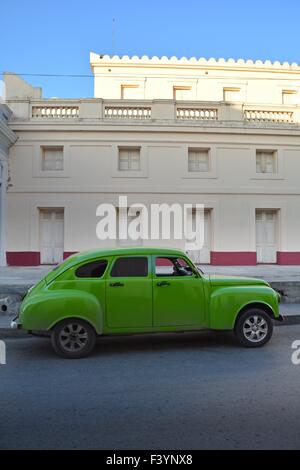 Vendemmia verde auto con vetri oscurati parcheggiato al di fuori di un edificio coloniale di Santa Clara, Cuba Foto Stock