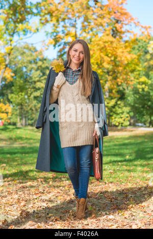 Donna sorridente su sfondo la natura in autunno Foto Stock