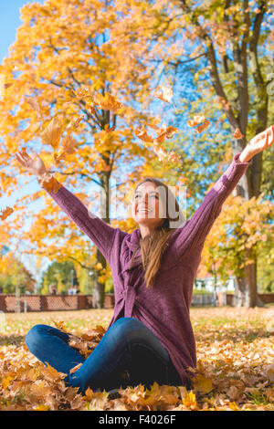 Felice giovane donna gioia in un parco di autunno Foto Stock