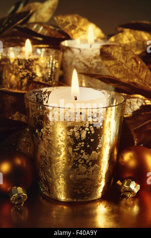 Candele accese con un frizzante tema oro Foto Stock