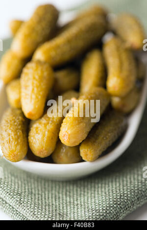 Piccola dill pickles nella ciotola in soft focus Foto Stock