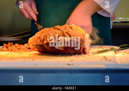 Grande pezzo di carne di maiale essendo intagliato Foto Stock