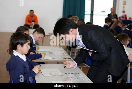 Londra, Regno Unito. Xvii Mar, 2015. File foto prese il 17 marzo 2015 mostra il cinese insegnante di matematica Jin Xiangjun(R) aiutare studenti locali che con le loro lezioni in Essex, Gran Bretagna. Il presidente cinese Xi Jinping pagherà una visita di Stato in Gran Bretagna da ott. 19 a 23. © Han Yan/Xinhua/Alamy Live News Foto Stock