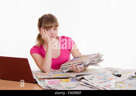 Ragazza triste con una pila di quotidiani Foto Stock