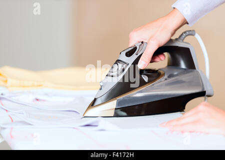 La mano della donna la stiratura di panni da vicino Foto Stock