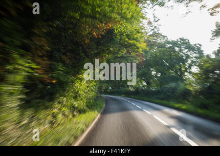 Accelerando giù per una strada di campagna visibile attraverso una finestra di auto Foto Stock