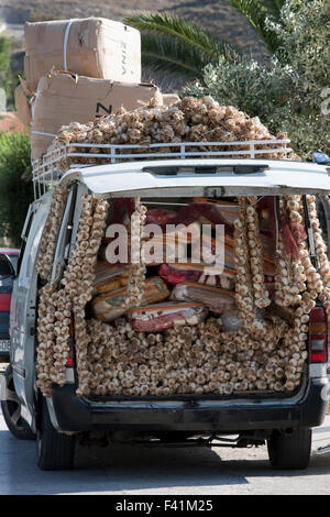 Pila di essiccato appeso spicchi di aglio per la vendita tra pacchi di coperte su uno zingaro Peddler's van. Foto Stock