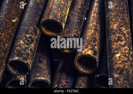 Rusty tubi metallici impilati, vicino il fuoco selettivo Foto Stock