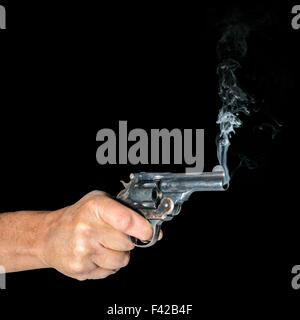 Isolato mano azienda revolver con canna fumante Foto Stock