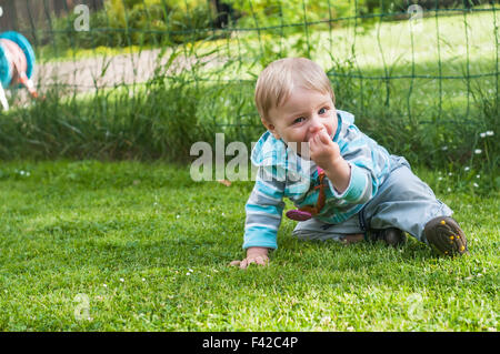 Bambino seduto sull'erba Foto Stock