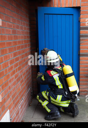 Pompiere apre una porta in uso Foto Stock