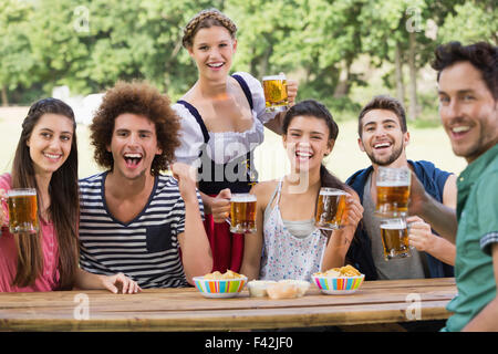 Bella ragazza oktoberfest che servono gli amici Foto Stock